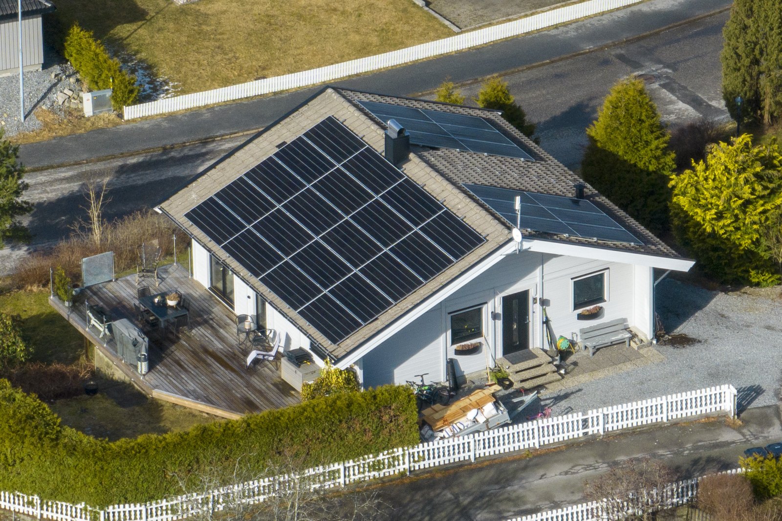 Dronebilde av en bolig med solcellepaneler fordelt på skråtaket